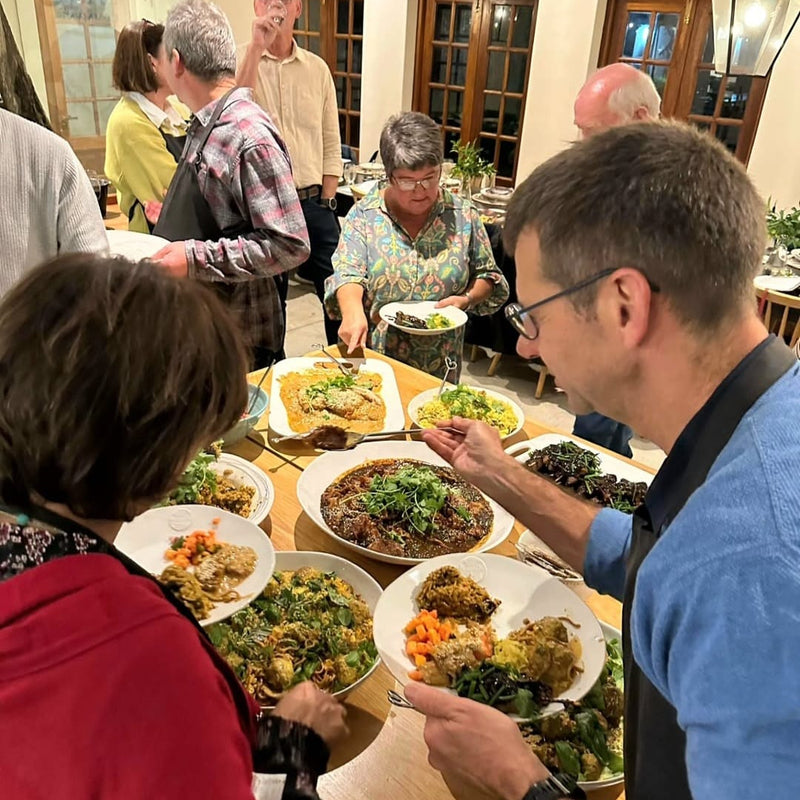 Group of people dining together with plates of food on a table.